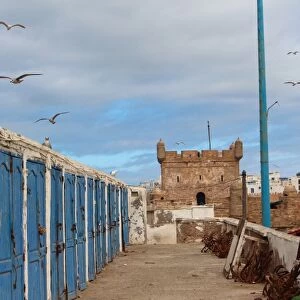 Fishermens huts and Genoese-built citadel in Essaouira harbour, on Atlantic coast of Morocco