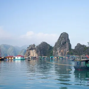 Floating Vietnamese fishing village with rocky coastline