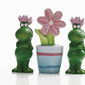 Two frog figures with artificial flower pot