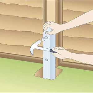 Illustration of using claw hammer to mark fixing holes in fence spur and wood post