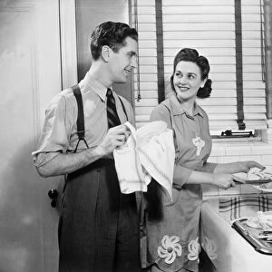 Man and woman doing dishes in kitchen