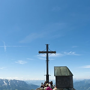 Mountain climber at the summit cross with a small chapel on Geigelstein Mountain, 1808 m, Geigelstein Nature Reserve, Aschau im Chiemgau, Upper Bavaria, Bavaria, Germany