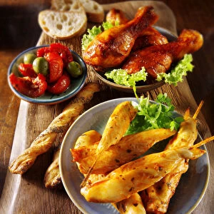Party buffet with chicken satay and grilled chicken legs