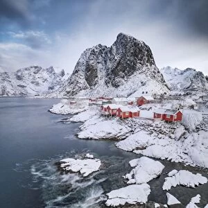 Rorbuer fishermens cabins on the snowy fjord, village view of the fishing village Hamnoy