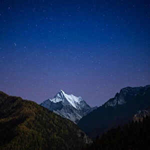 Snowy mountain peak at night with the stars