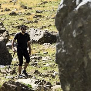 Tripper with rucksack and stick crossing a way of high mountain in the pyrenees, Gavarnie