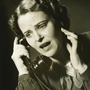 Woman on phone in studio, (B&W), close-up, portrait