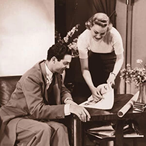 Woman showing brochure to man (B&W sepia tone)