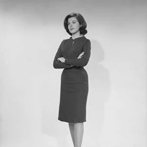 Woman standing with arms crossed, studio shot