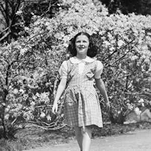 Young girl (8-9) walking on garden path, (B&W)