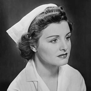 Young nurse sitting, looking away, (B&W)