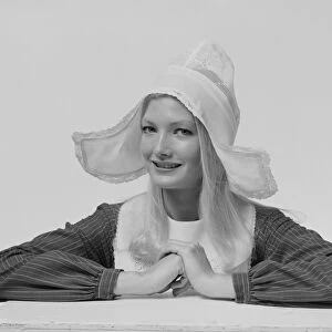 Young woman wearing dress hat, smiling, portrait