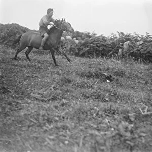 A boy riding a horse, bareback, galloping on a field. 1933