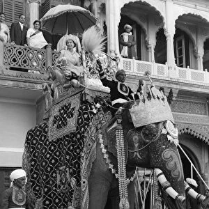H. M. Queen Elizabeth II smiles from atop a ten-feet high elephant at Ramnagar Fort