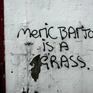 Meric Barton is a grass: graffiti on the side of a building denouncing a local person