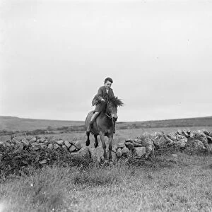 A young boy rides a horse bareback. 1936