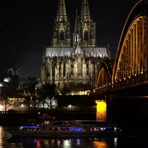 The Hohenzollern bridge is seen in front of the Cologne cathedral on December 31