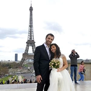 A mixed American and Roumanian newly married couple poses in front of the Eiffel tower on March 21
