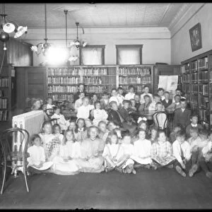 Group portrait of children in the reading room of an unidentified branch of the Queens