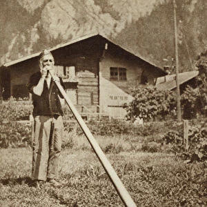 Man blowing an alphorn in the Alps (b / w photo)
