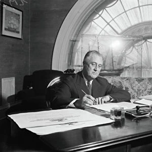 President Franklin Roosevelt in the White House signing bills and preparing his speeches for his Southern trip, 1936 (b/w photo)