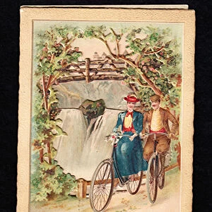 A Victorian three dimensional Christmas card of a man and a woman bicyling next to a