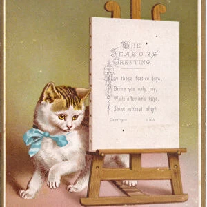 A Victorian greeting card of a cat next to an easel with seasonal message on it, c