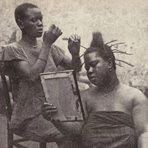 West African woman having her hair done (b / w photo)