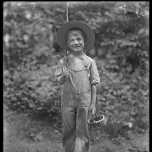 William Gray Hassler in straw hat and overalls, carrying fishing pole