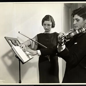 Woman teaching a blind young man to play the violin at the New York Association for