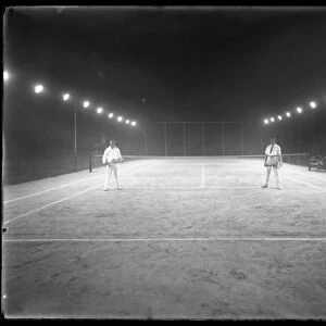 Two young men on unidentified clay tennis court at night, July 1915 (b / w photo)