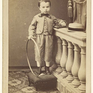 little boy standing ottoman holding hoop A Dupre