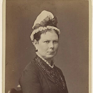 woman wearing bonnet bow seated hands together