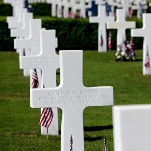 American flags rest in front of headstones at Madingley American Cemetery