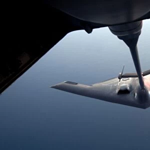 A B-2 Spirit bomber conducts a refueling with a KC-10 Extender