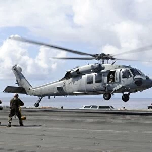 An MH-60S Sea Hawk lands on the flight deck of USS John C. Stennis