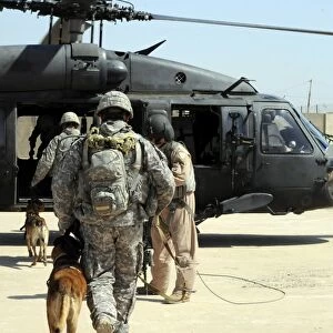 Military working dog handlers board a helicopter