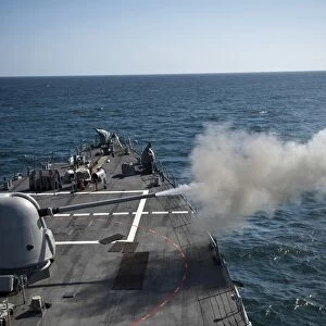 An Mk-45 lightweight gun is fired aboard guided missile destroyer USS Arleigh Burke