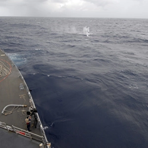 A sailor fires a. 50-caliber machine gun aboard guided missile destroyer USS Nitze