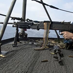 A Sailor fires an M-240B machine gun aboard USS Enterprise