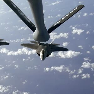 A three ship formation of F-22 Raptors move into refueling position