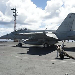 Shooters give the signal to launch an F / A-18E Super Hornet