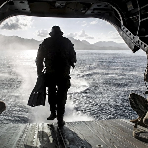 A soldier conducts a combat dive mission off the back of a CH-47 Chinook