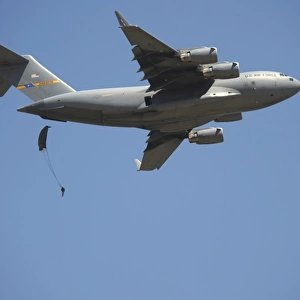 A U. S. Army paratrooper parachutes from a C-17 Globemaster III cargo aircraft