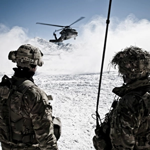 U. S. Army soldiers watch the arrival of a helicopter at an outpost in Afghanistan