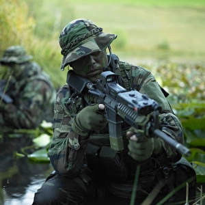 U. S. Navy SEALs cross through a stream during combat operations