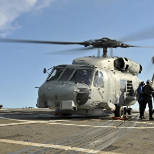 A U. S. Navy SH-60B Seahawk helicopter is refueled on the flight deck of USS Thach
