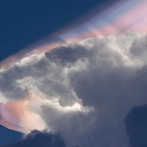 Cloud iridescence forming above a cumulonimbus cloud, caused by light refraction