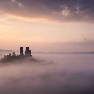 Corfe castle and village at dawn with mist, Corfe Castle, The Purbecks, Dorset, UK