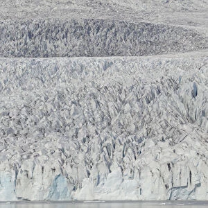 Zodiac carrying visitors navigating among ice floes at foot of Fjallsarlon Glacier, Iceland. July